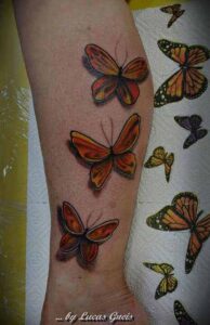 Drei bunte 3D Schmetterlinge Tattoo Idee am Bein