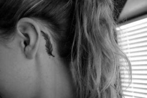 Feder Tattoo hinterm Ohr