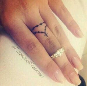 Minimalistisches Rosenkranz Tattoo Design am Finger