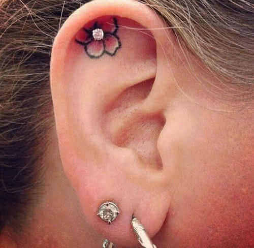 Tattoo kleine Blume im Ohr