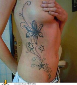 Orchidee Tattoo Idee mit Sternen und Ornamenten auf den Rippen