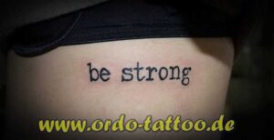 Schriftzug be strong unter der Brust