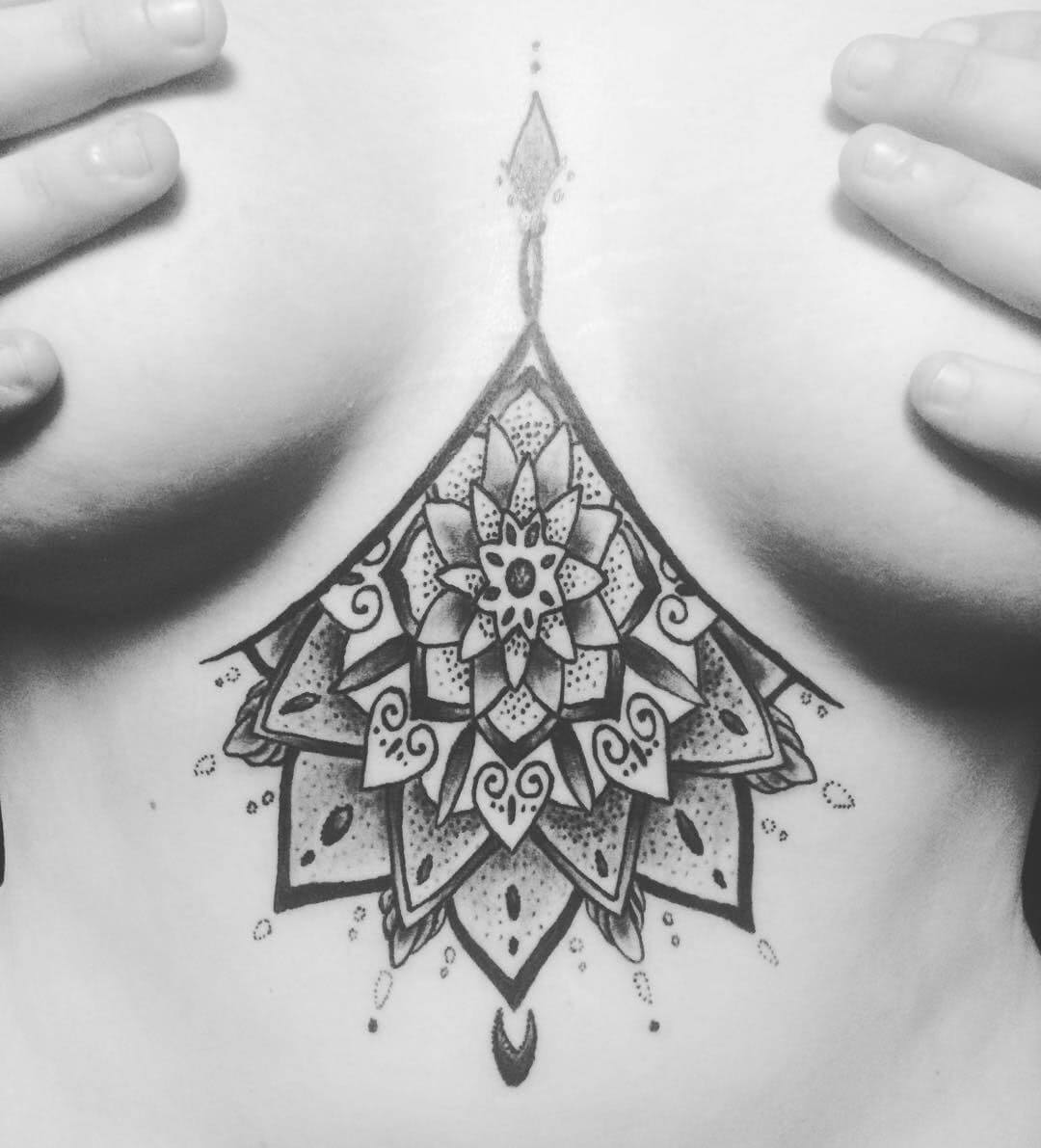 abstraktes Tattoo zwischen den Brüsten