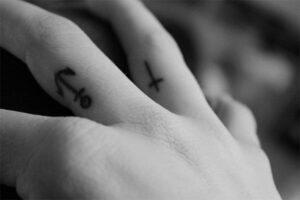 Anker und Kreuz am Finger