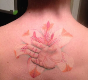 Babyhand mit Blume