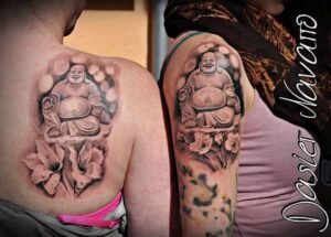 Realistisches Buddha Tattoo Motiv mit Blumen am Oberarm