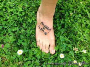 Designed by God Spruch Tattoo als Stempel auf dem Fuß