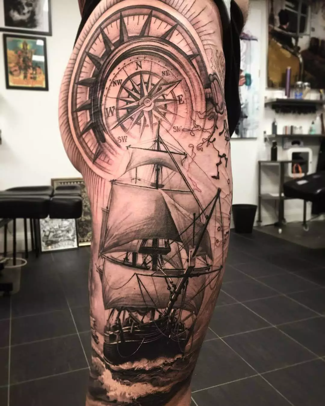 Kompass und Segelschiff auf dem Bein