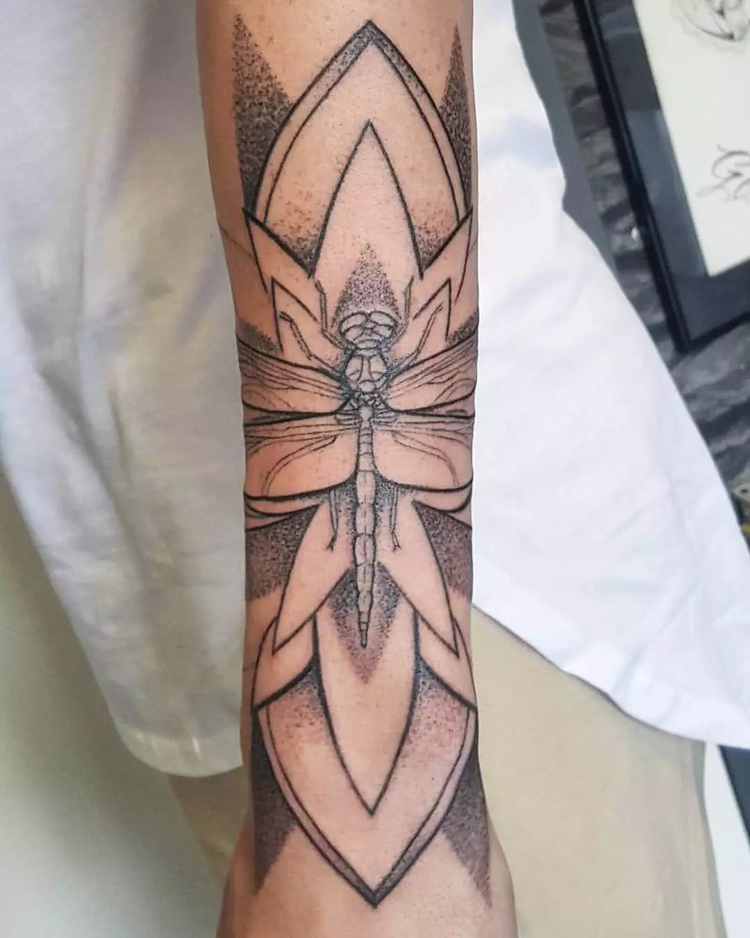 Libelle mit Blume auf dem Unterarm